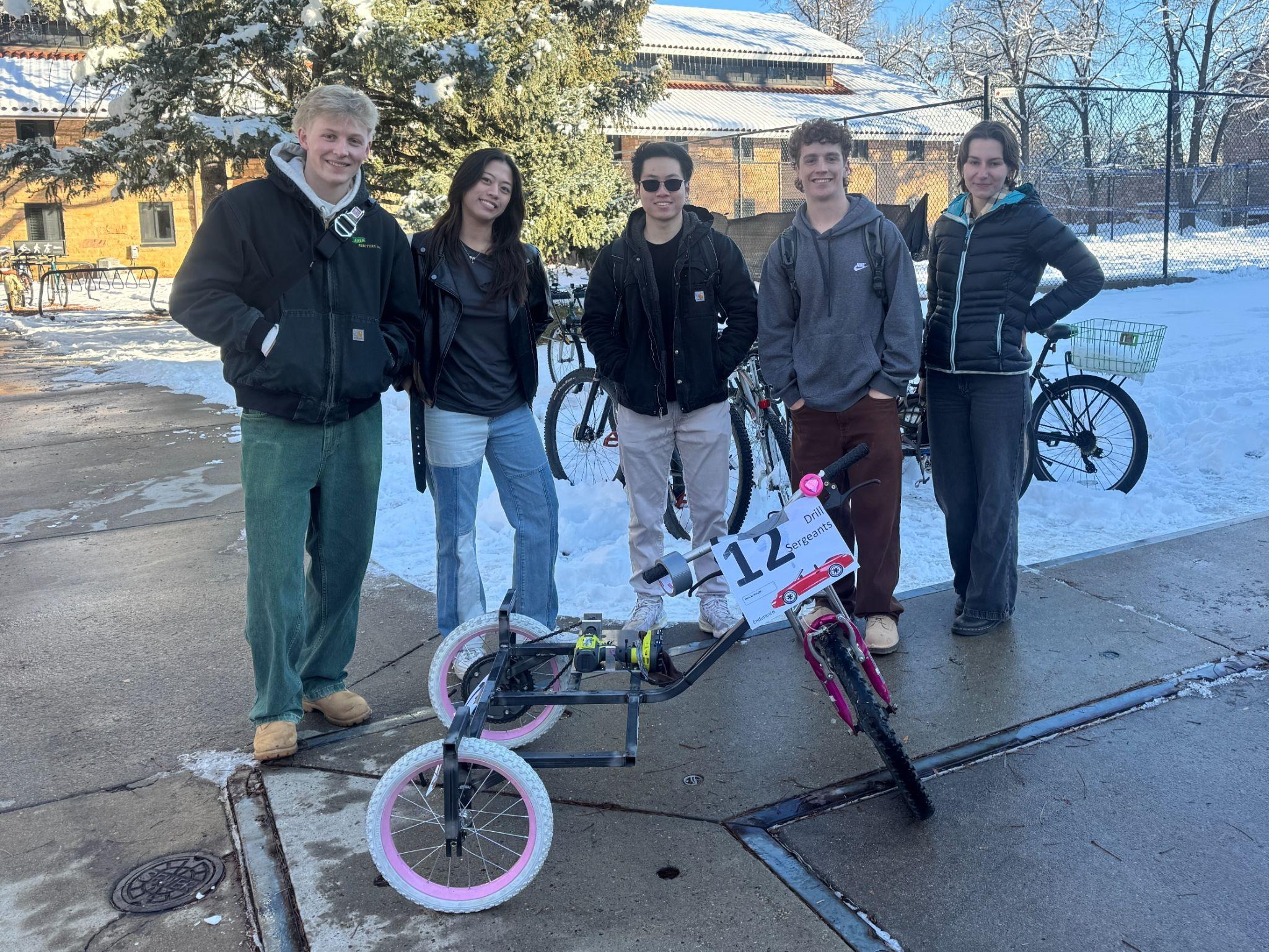 The project team standing around the completed drill-powered tricycle